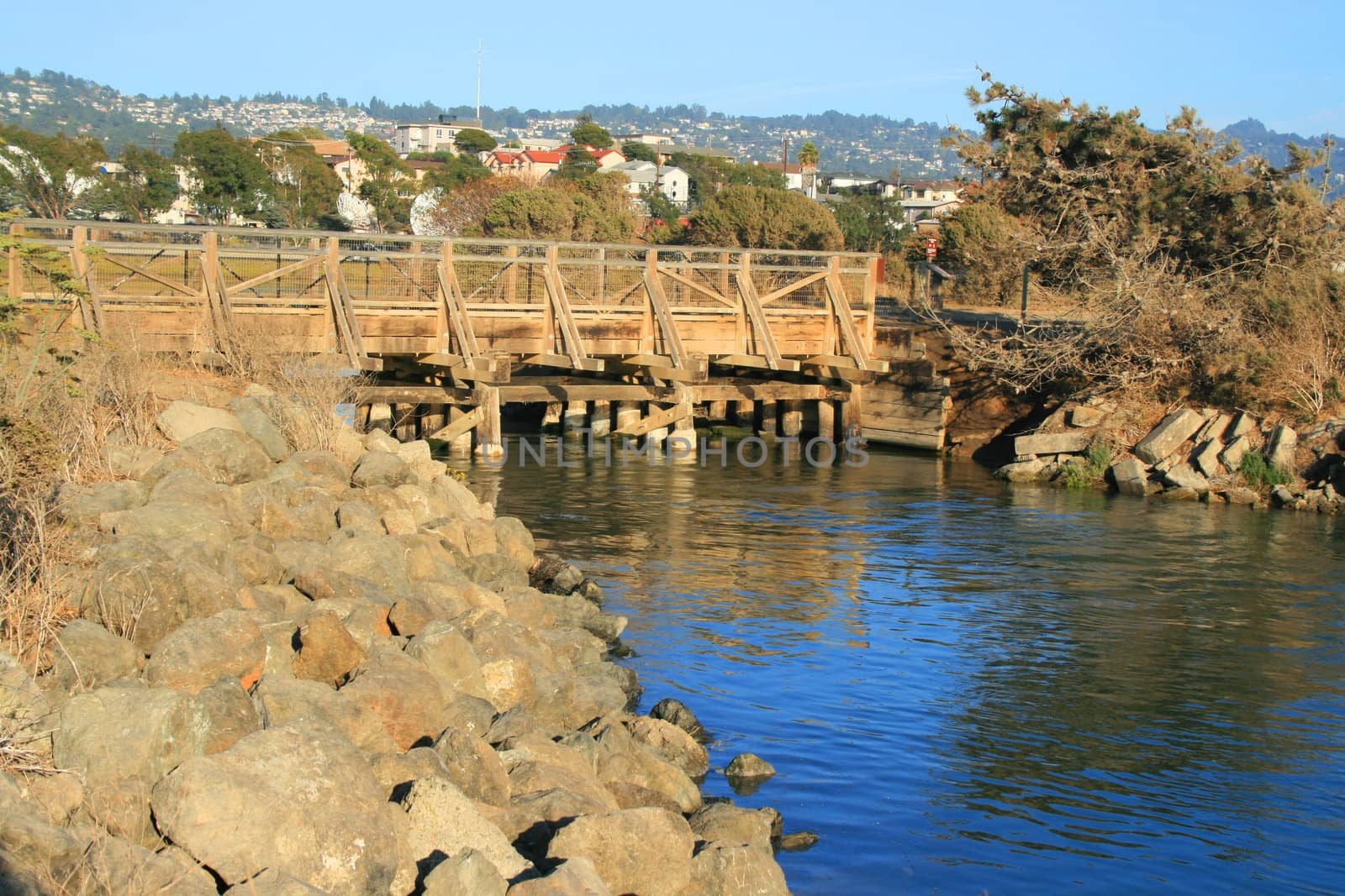 Small wood bridge built over a river.
