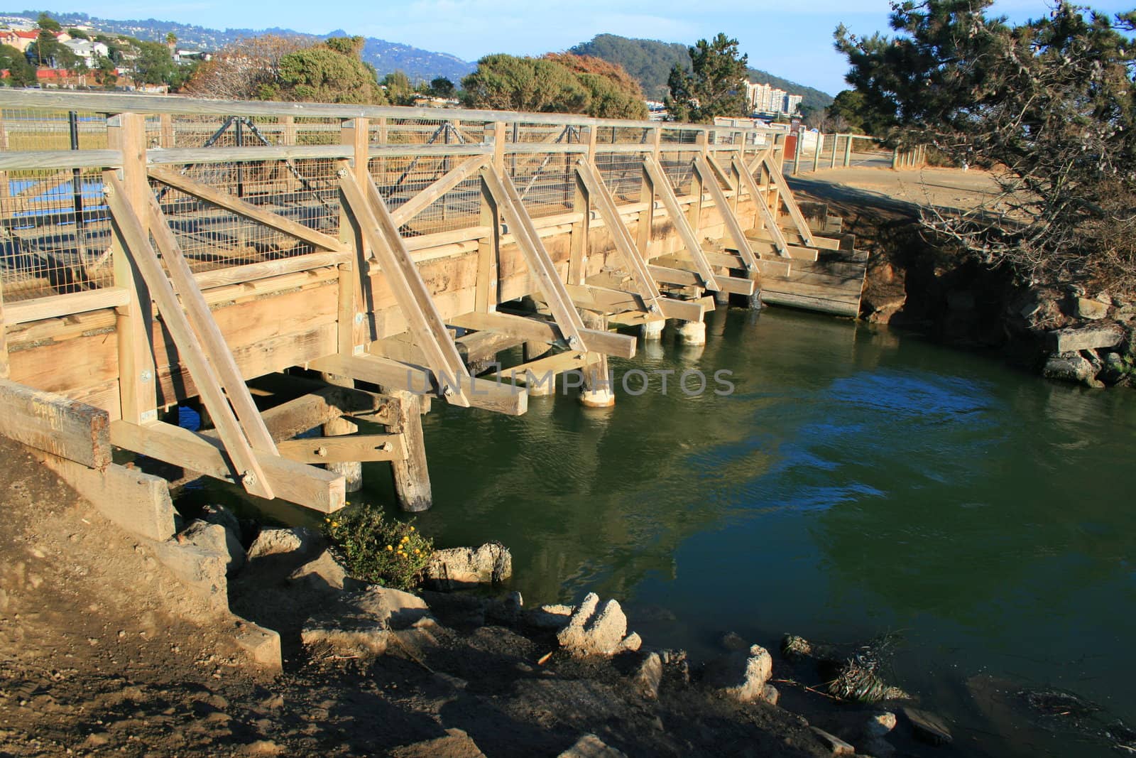 Small wood bridge built over a river.
