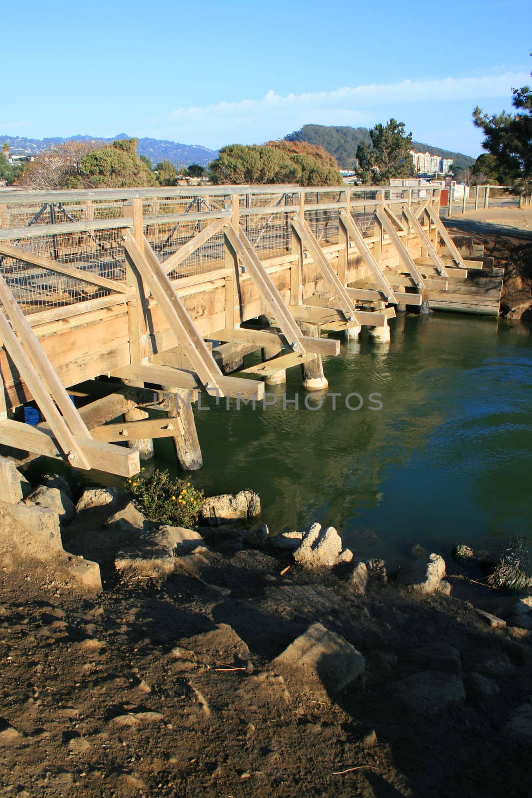 Small wood bridge built over a river.
