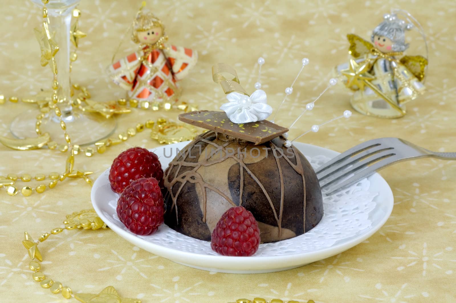 Festive chocolate dessert decorated with raspberries on a plate with paper doily