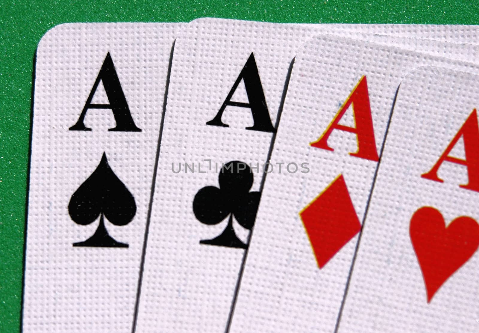 four aces seen up close in a green table