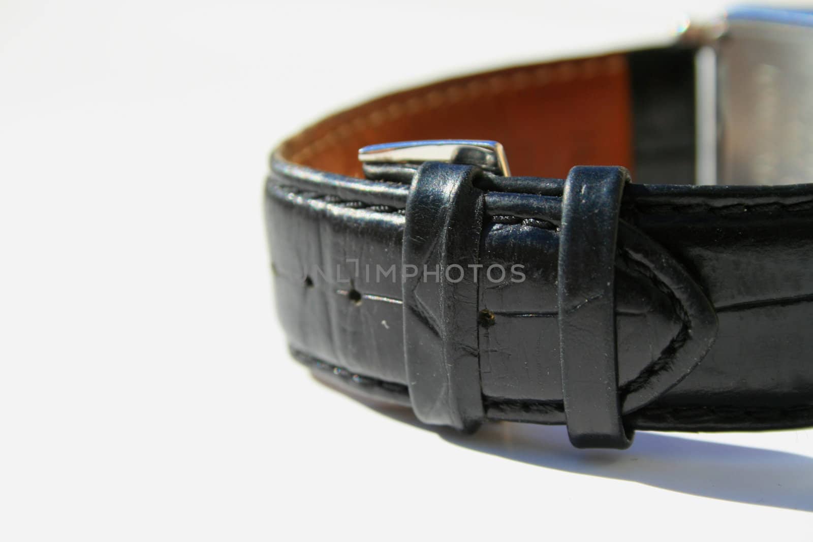 Close up of a leather watch band on a white background.

