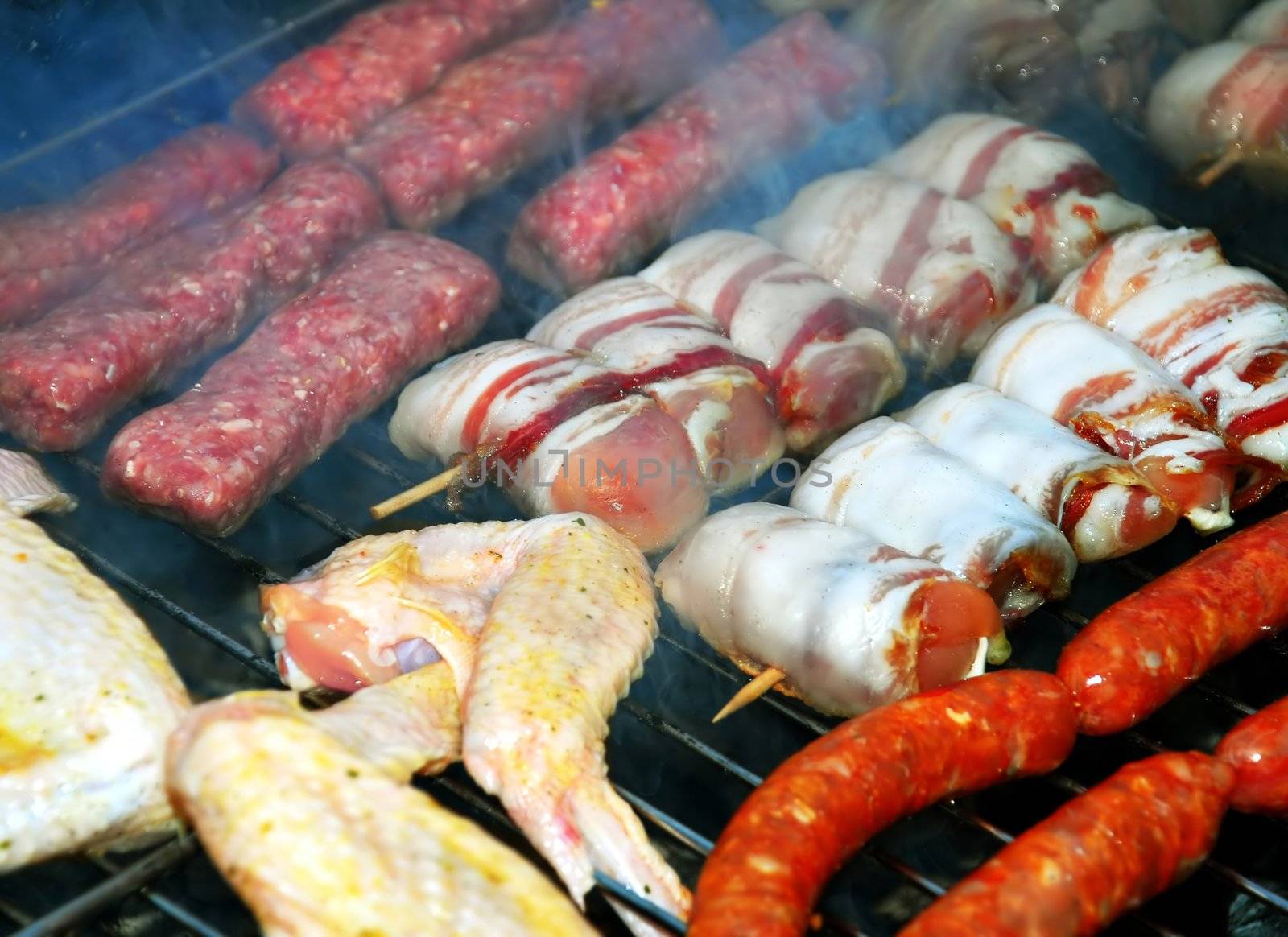 various meat grilled on barbecue in smoke