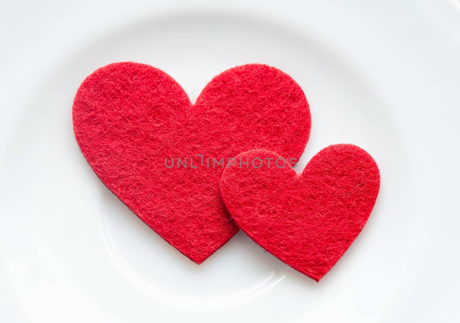 Red hearts on a plate close-up. Valentine's Day by sfinks