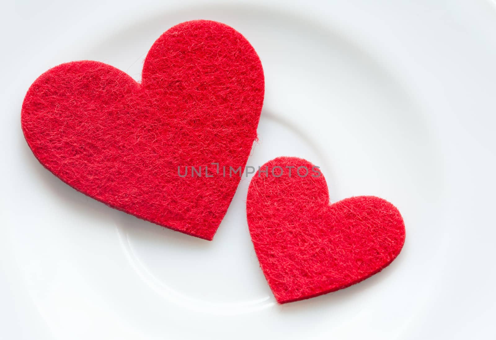 Red hearts on a plate close-up. Valentine's Day by sfinks