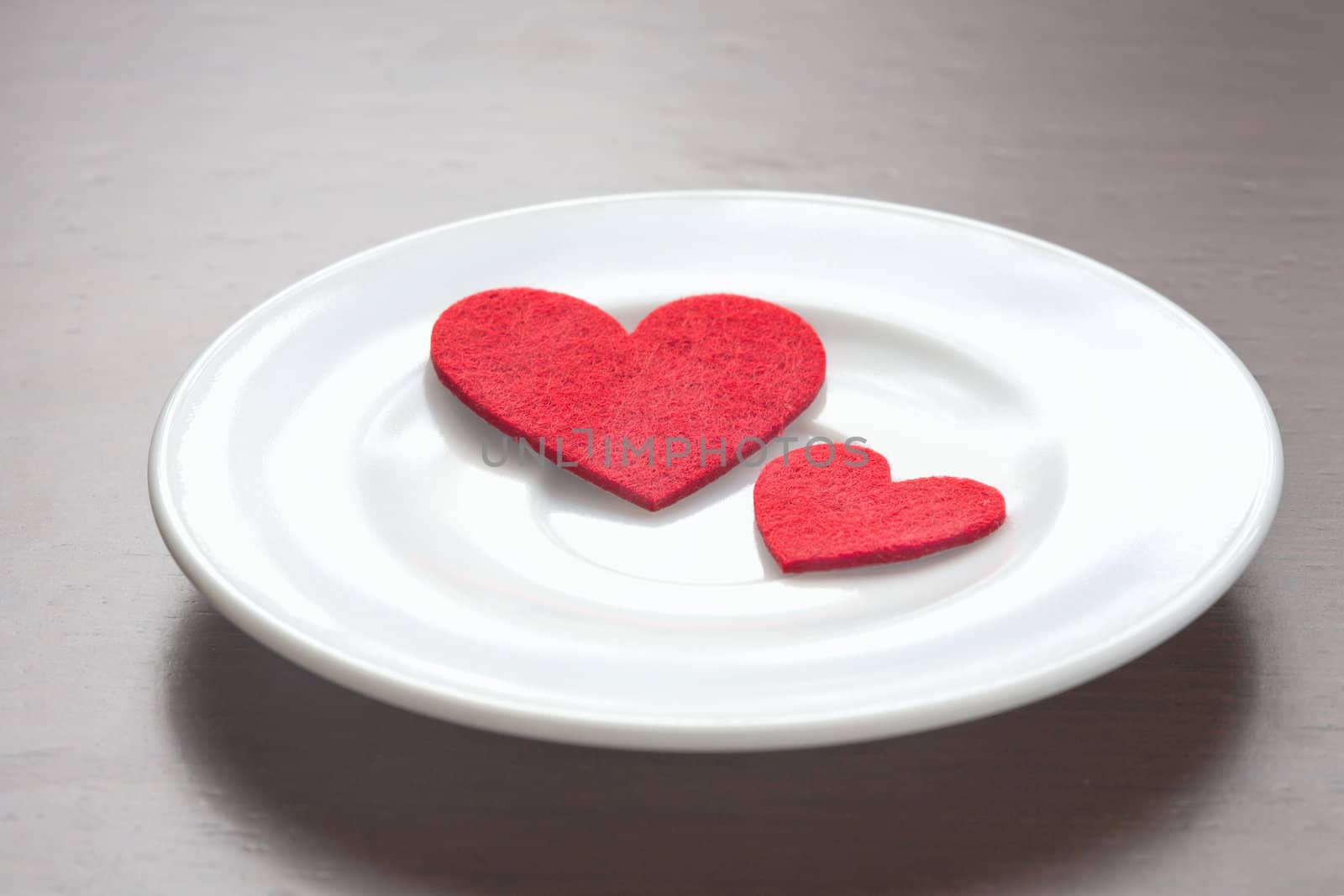 Red hearts on a plate by sfinks