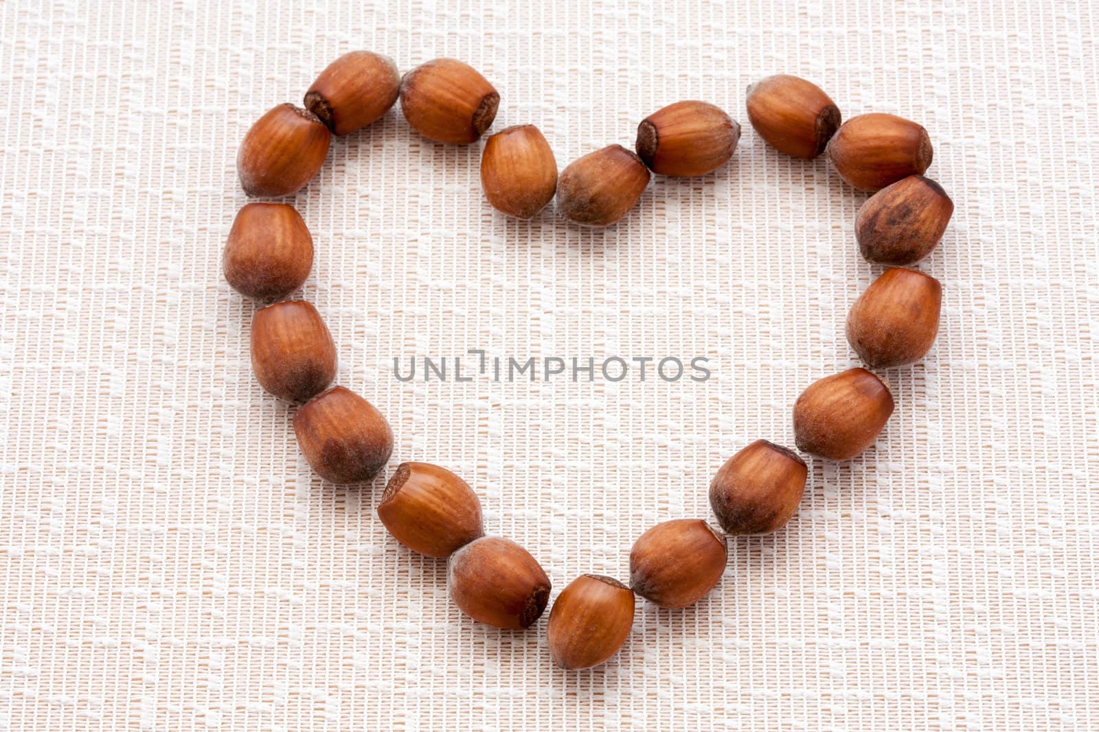 walnuts, hazelnuts on a wooden background in the form of heart