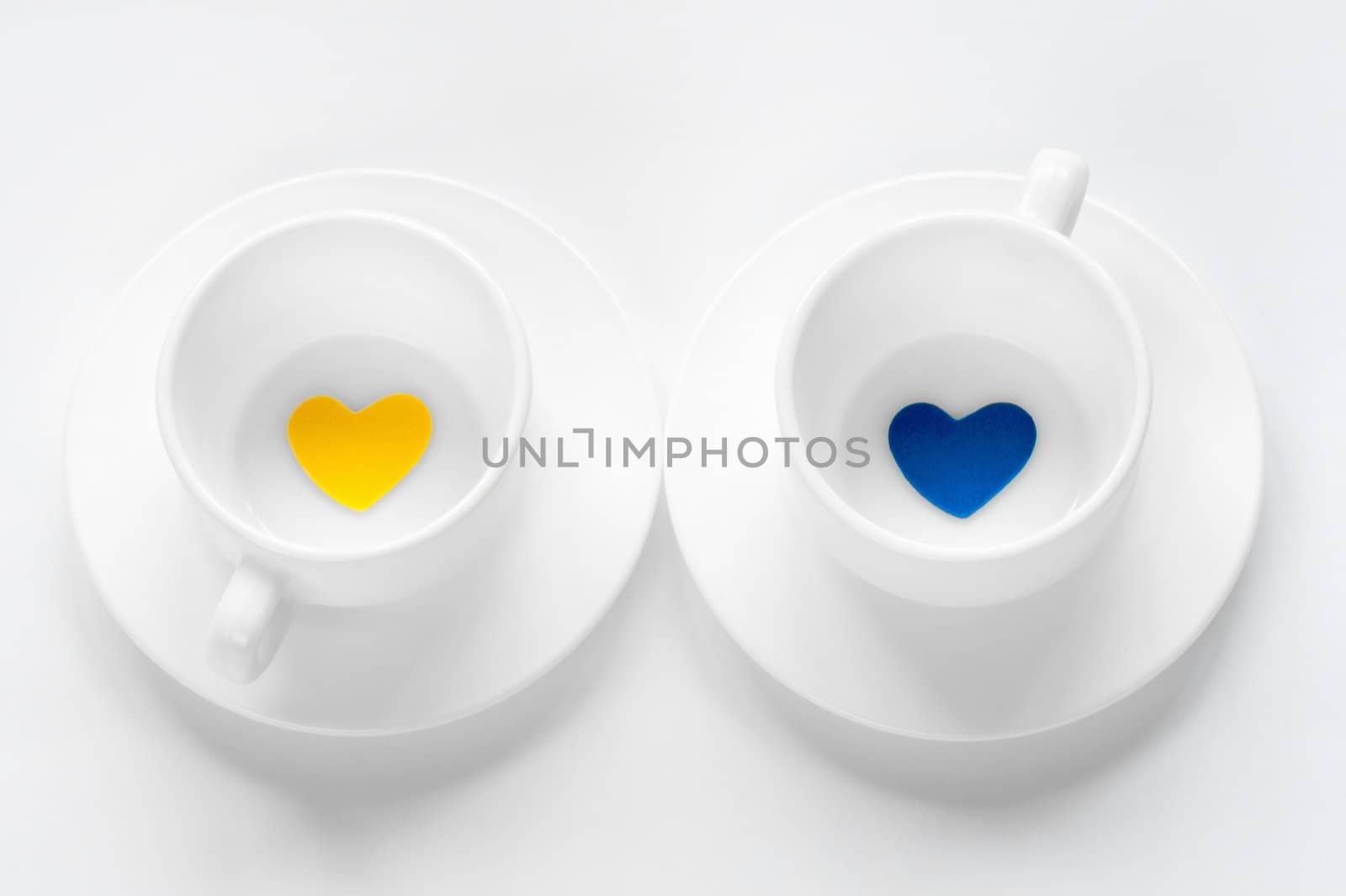 empty cup and saucer with hearts on white