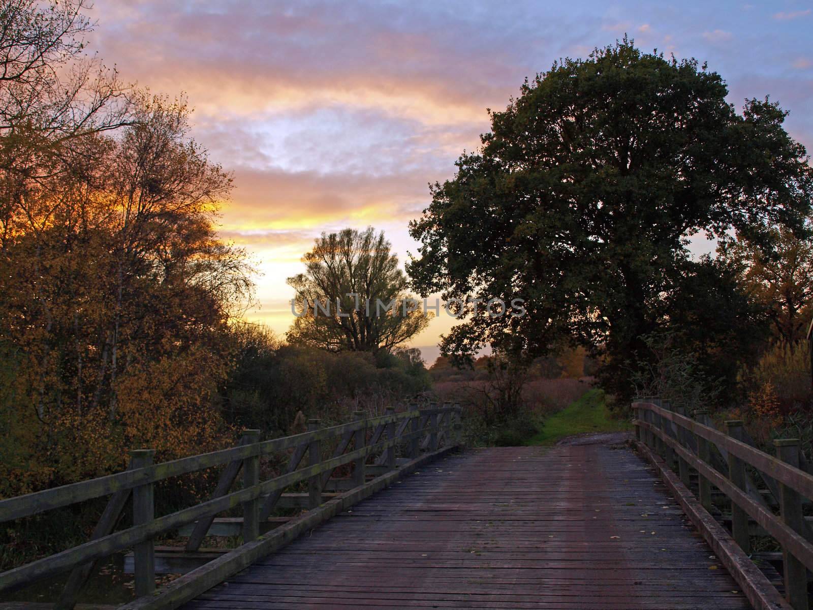 Photo taken on an autumn day at sunset of the bridge over Great Raveley Drain, at the entrance to Woodwalton fen.