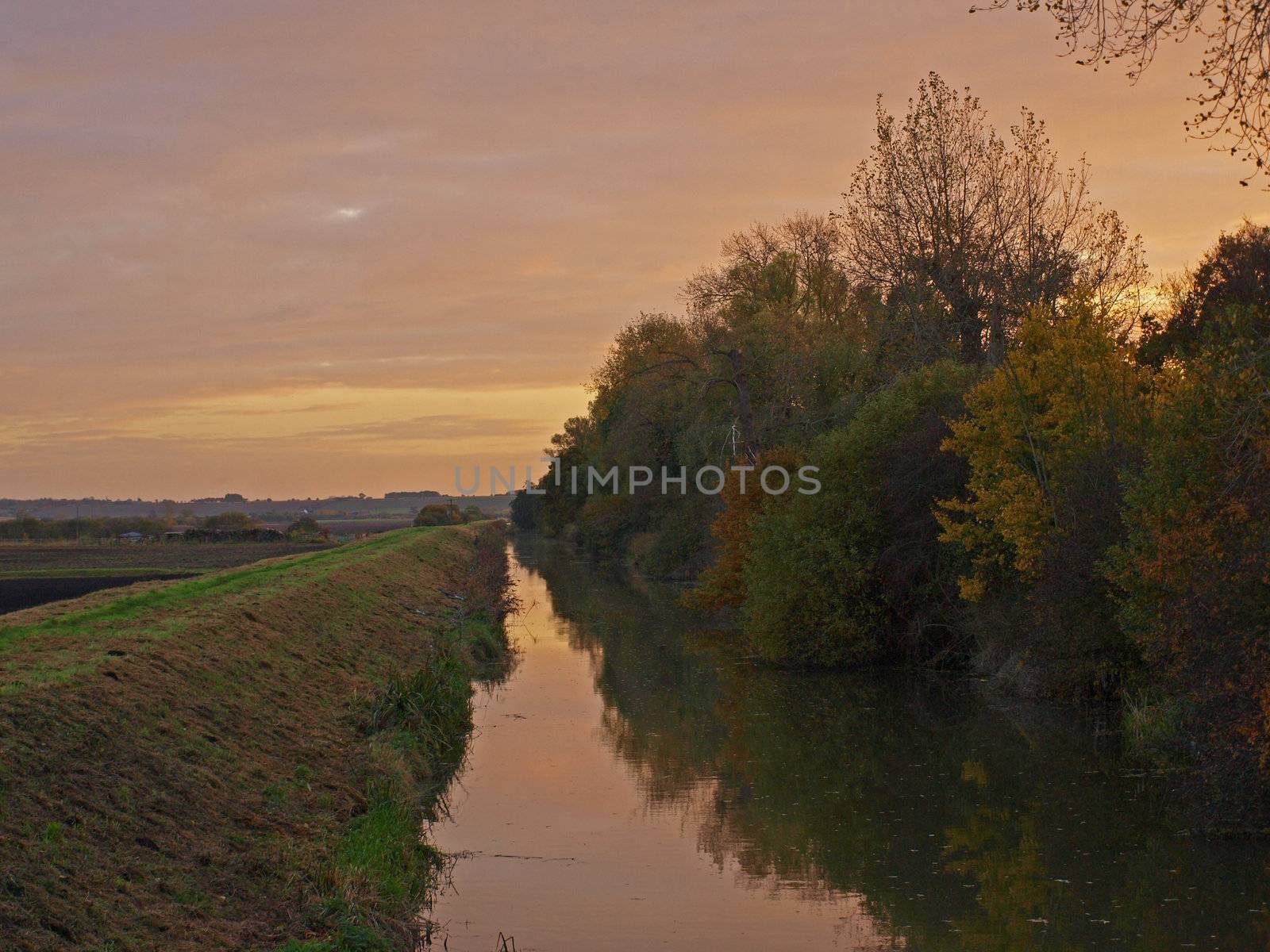 Photo taken on an autumn day at sunset from the bridge over Great Raveley Drain, at the entrance to Woodwalton fen.