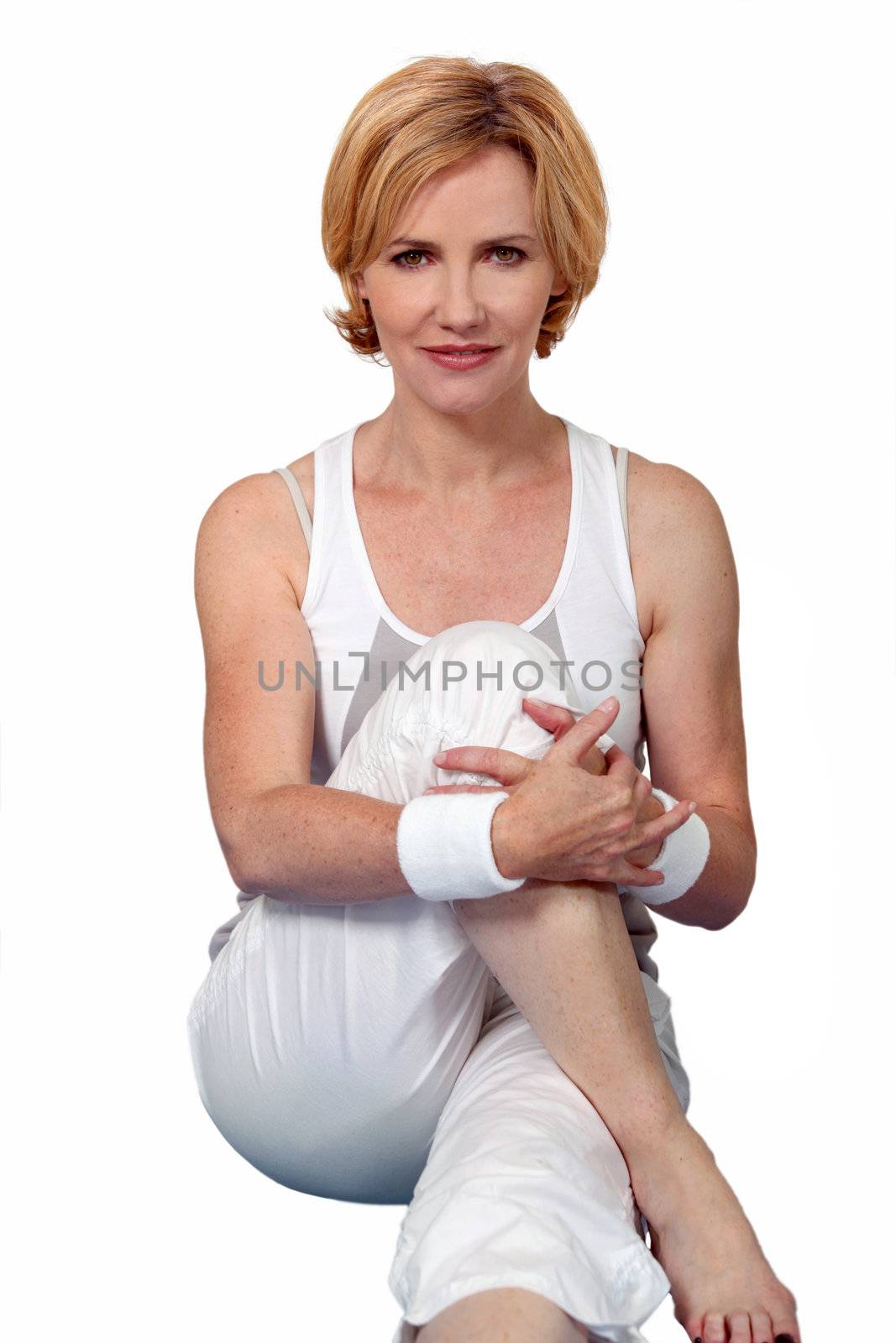 Woman practising yoga on a mat by phovoir