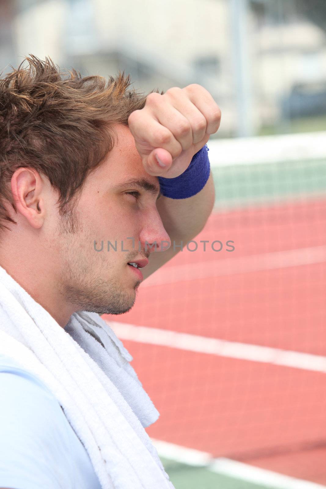 Tired man by tennis court by phovoir