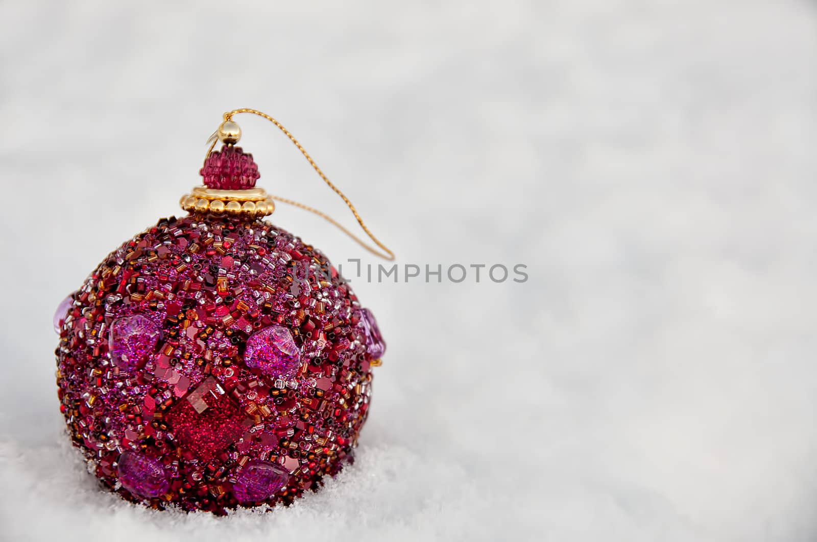 A purple christmas bulb in the snow.  Islolated