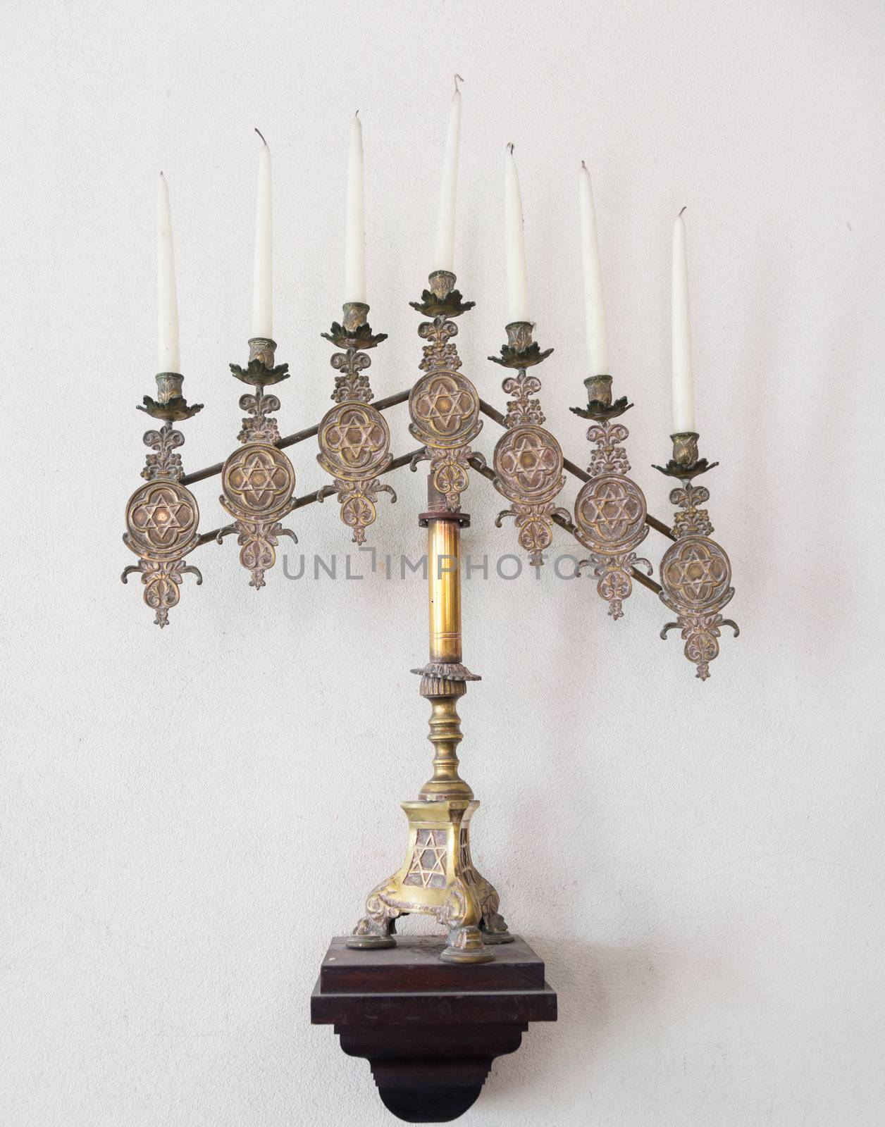 Antique ornate menorah in brass with old tallow candles