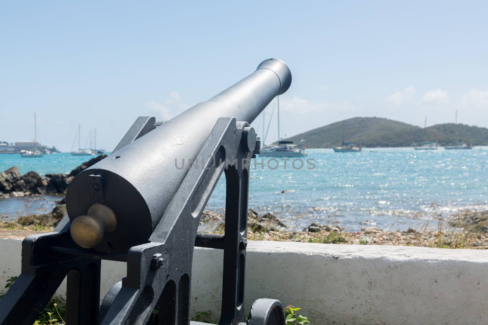 Panoramic view of Charlotte Amalie harbor with old cannon in foreground
