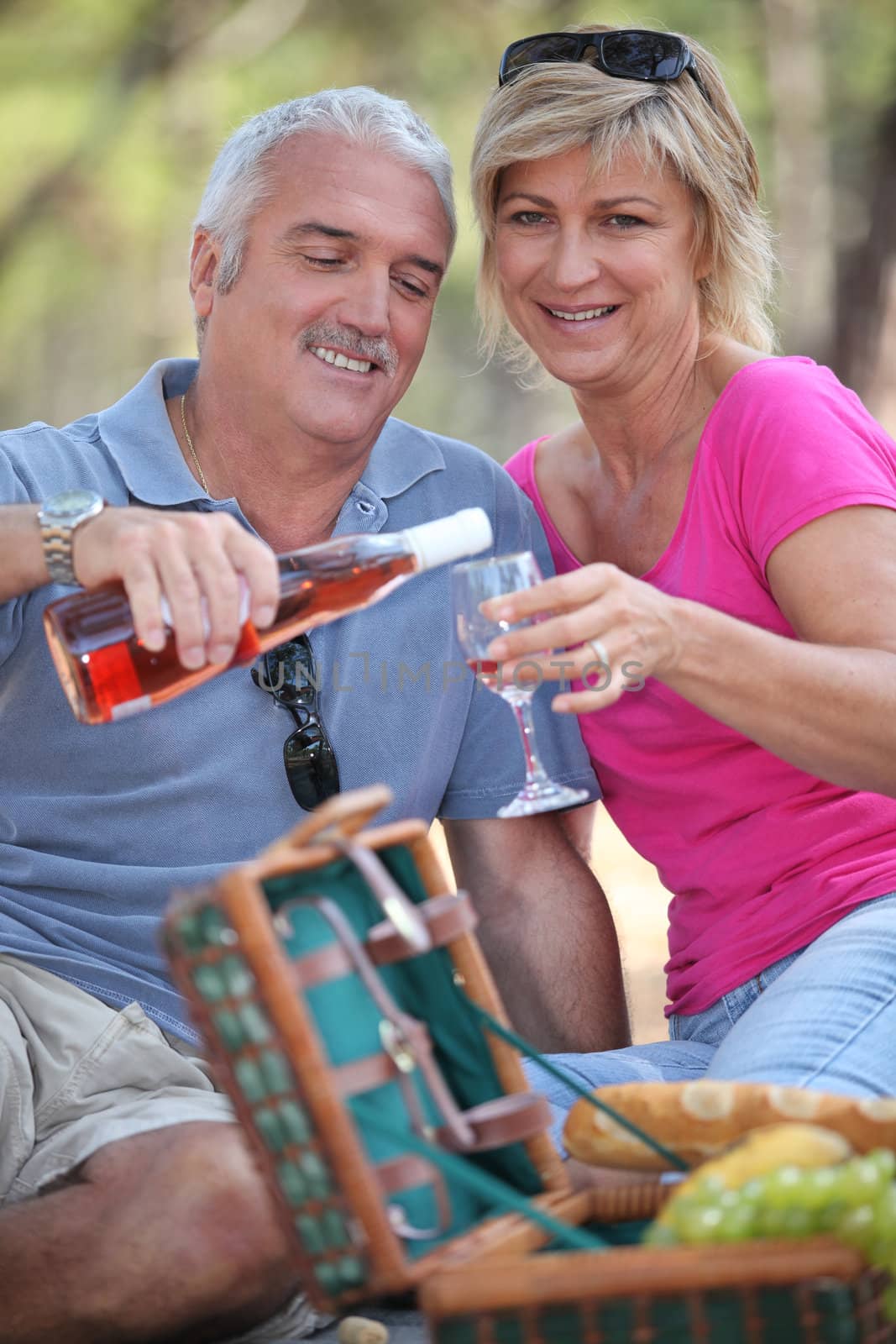 Couple enjoying a picnic together by phovoir