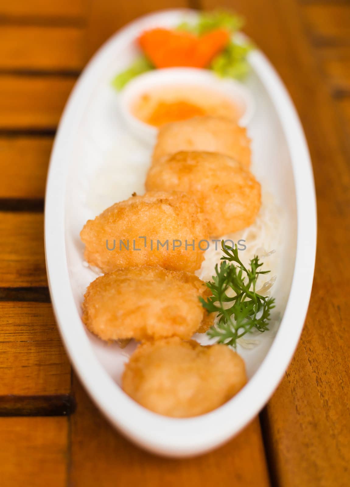 fried shrimp cakes on white dish on wood  table thai food