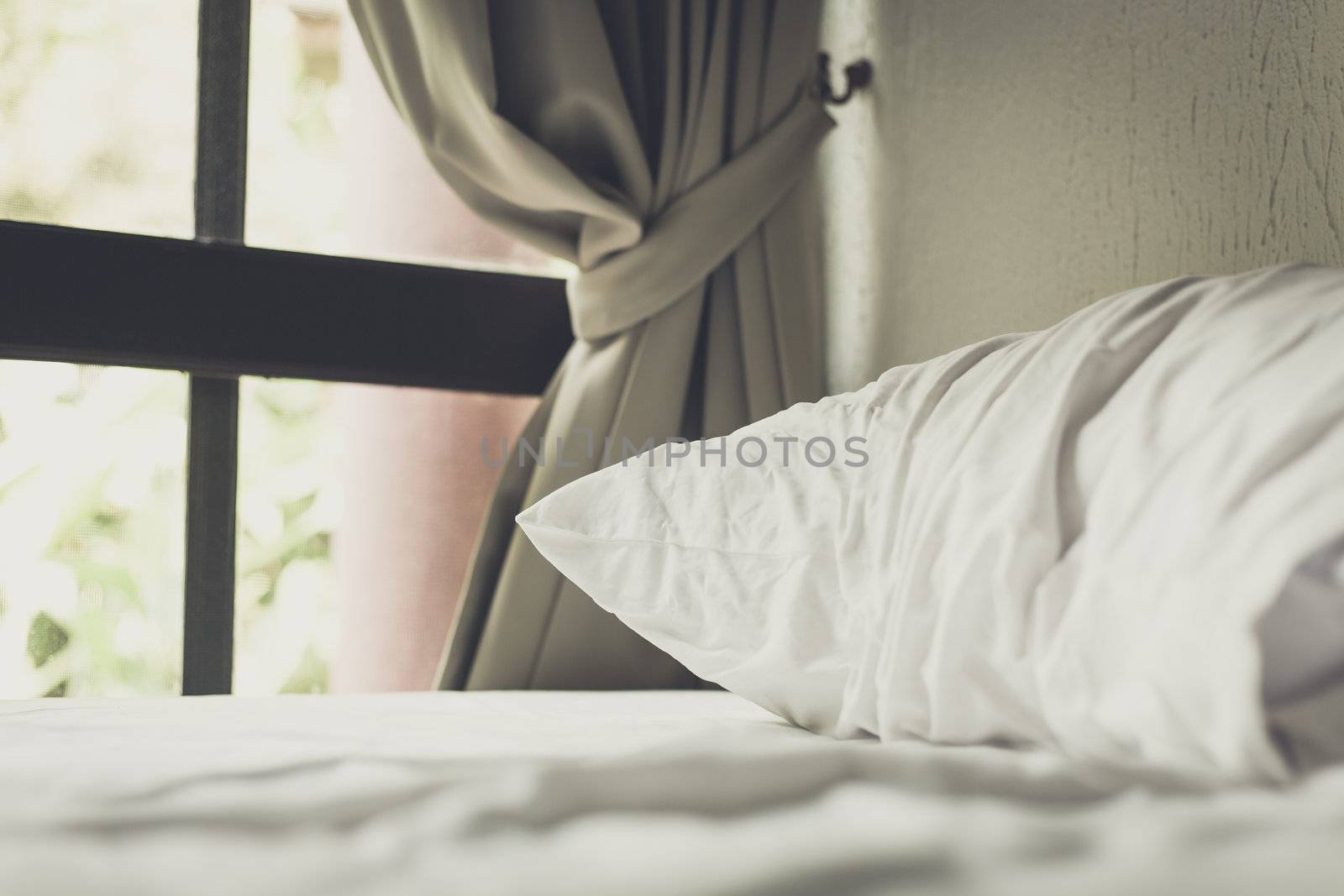 white pillow on bed in room in morning time process photo in retro style