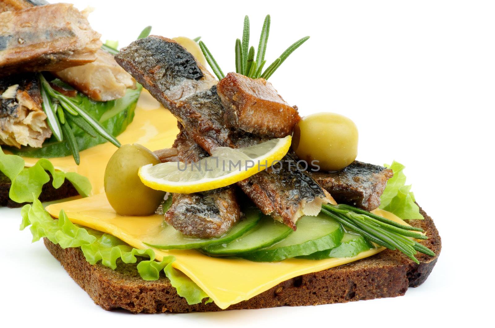 Sandwiches with Smoked Sardines, Cucumber, Cheese, Green Olive, Lettuce and Whole Wheat Bread closeup on white background