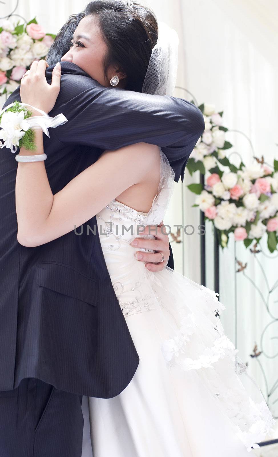 a young couple embracing on their wedding day by jackq