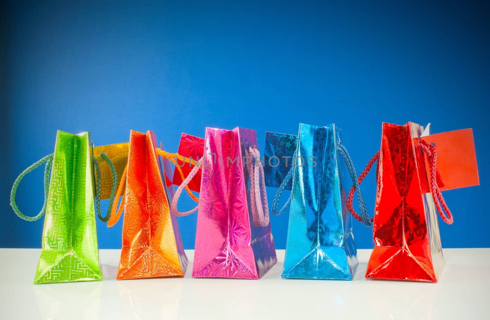 Row of colorful bags against blue background