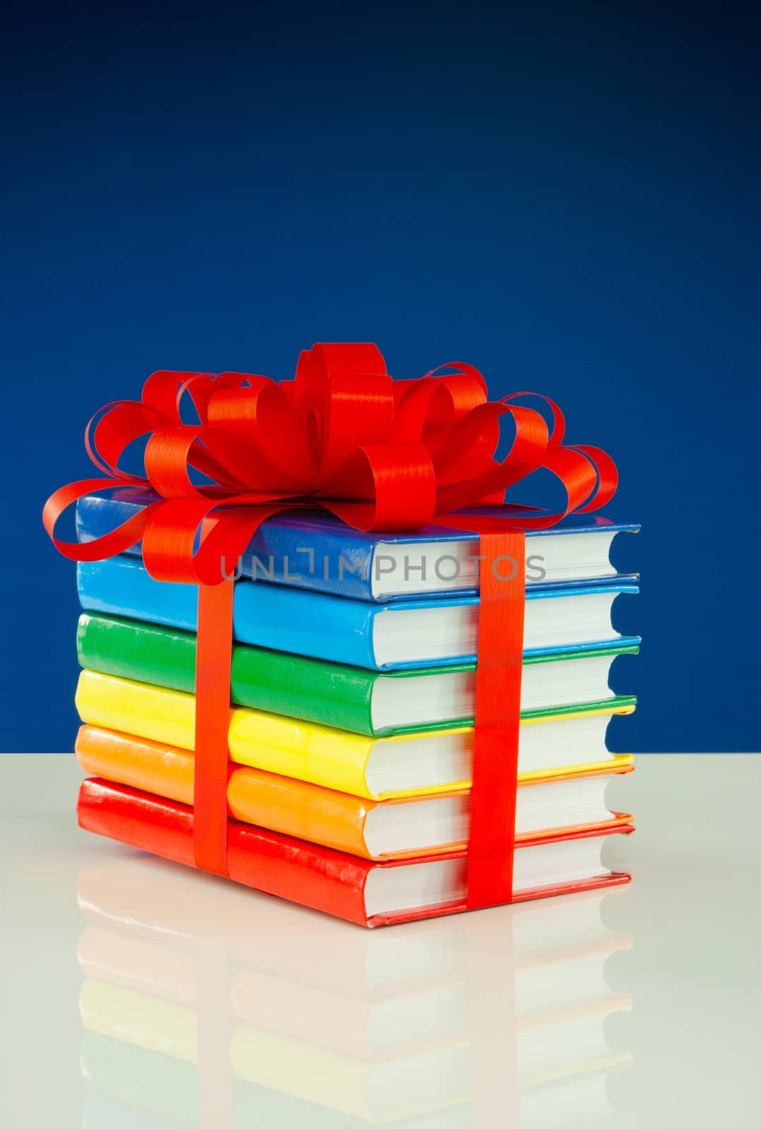 Stack of colorful books tied up with red ribbon