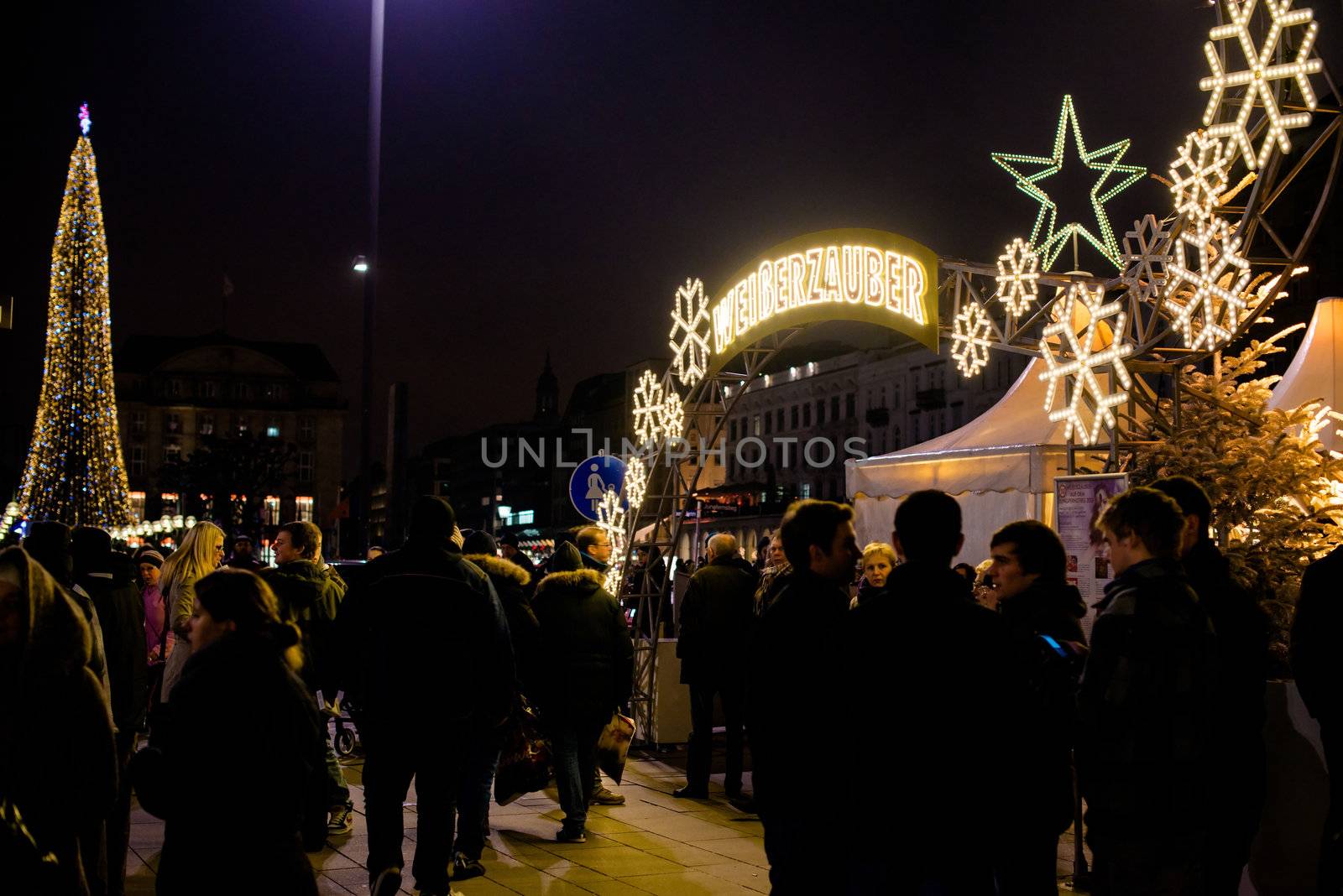 HAMBURG - DECEMBER 1, 2012: People visit traditional Christmas market around Alster river in Hamburg, Germany on December 1, 2012. The famous Hamburg Christmas market is located around the town hall and is a popular tourist attraction due to its gorgeous decorated stands.