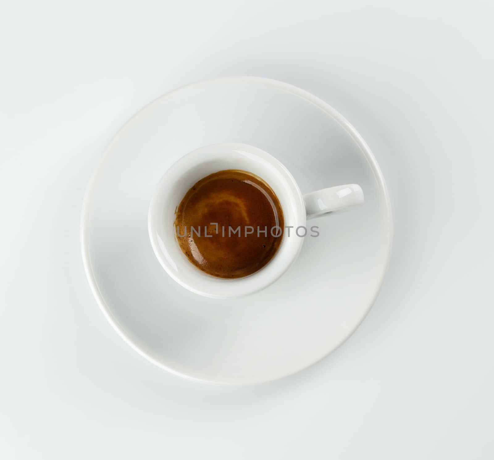 Cup of espresso viewed from above on white table