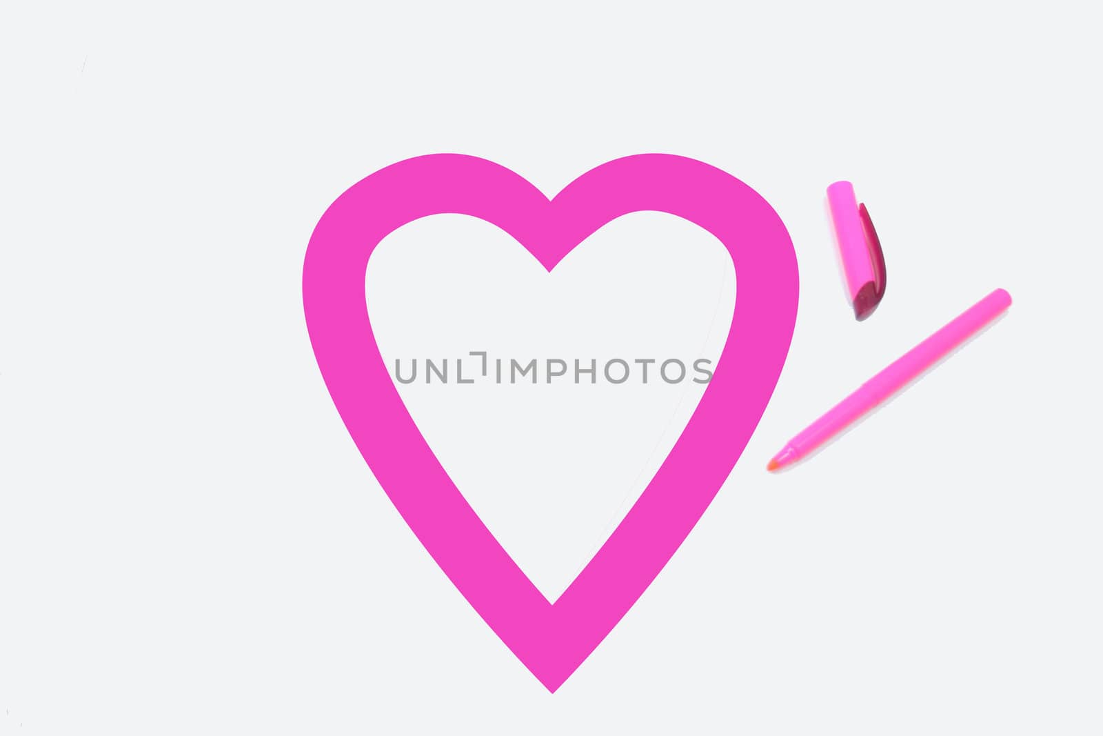 Heart shape colored pink by office highlighter on white background