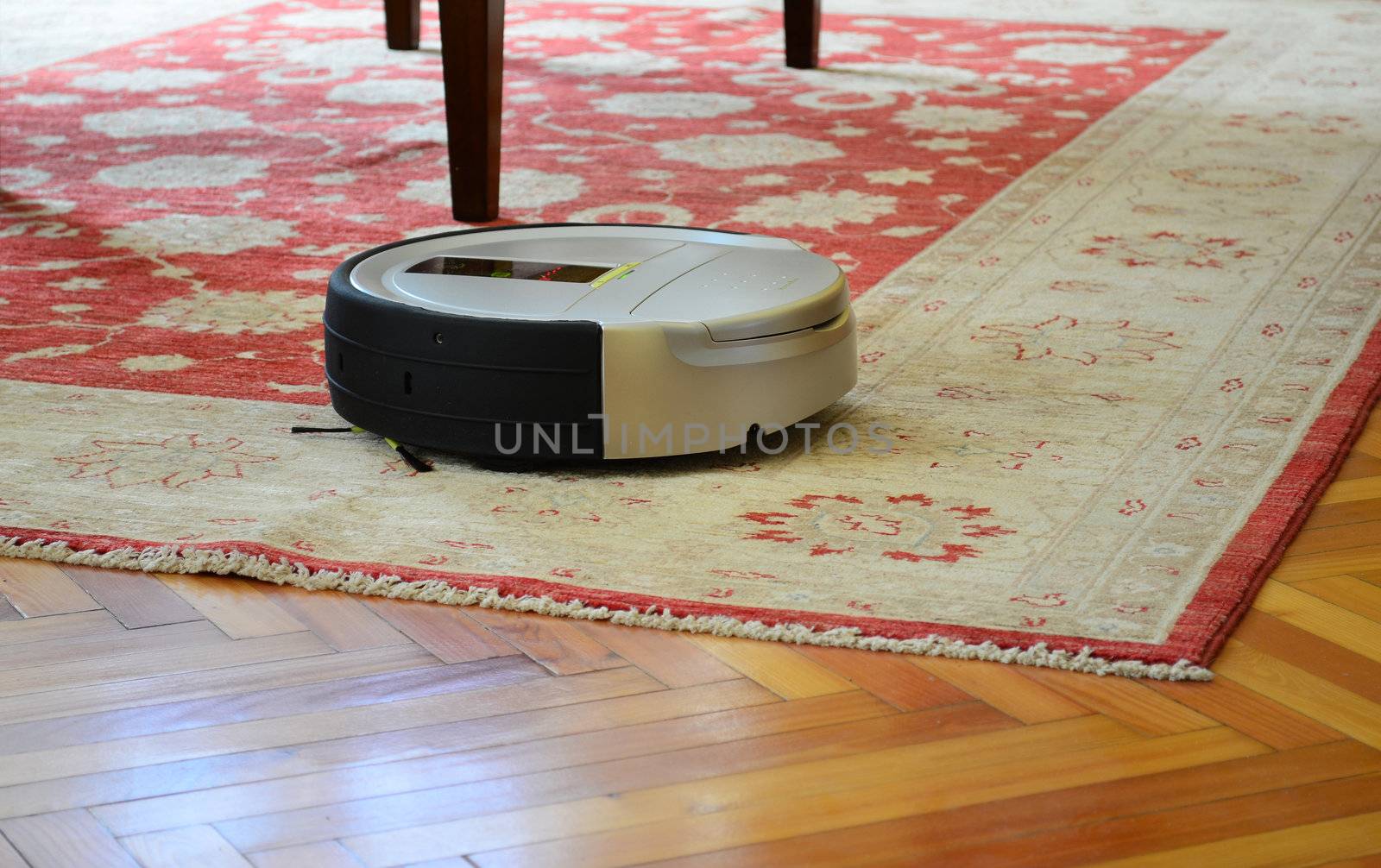Automatic cleaning with robot vacuum cleaner on rug and hardwood floor
