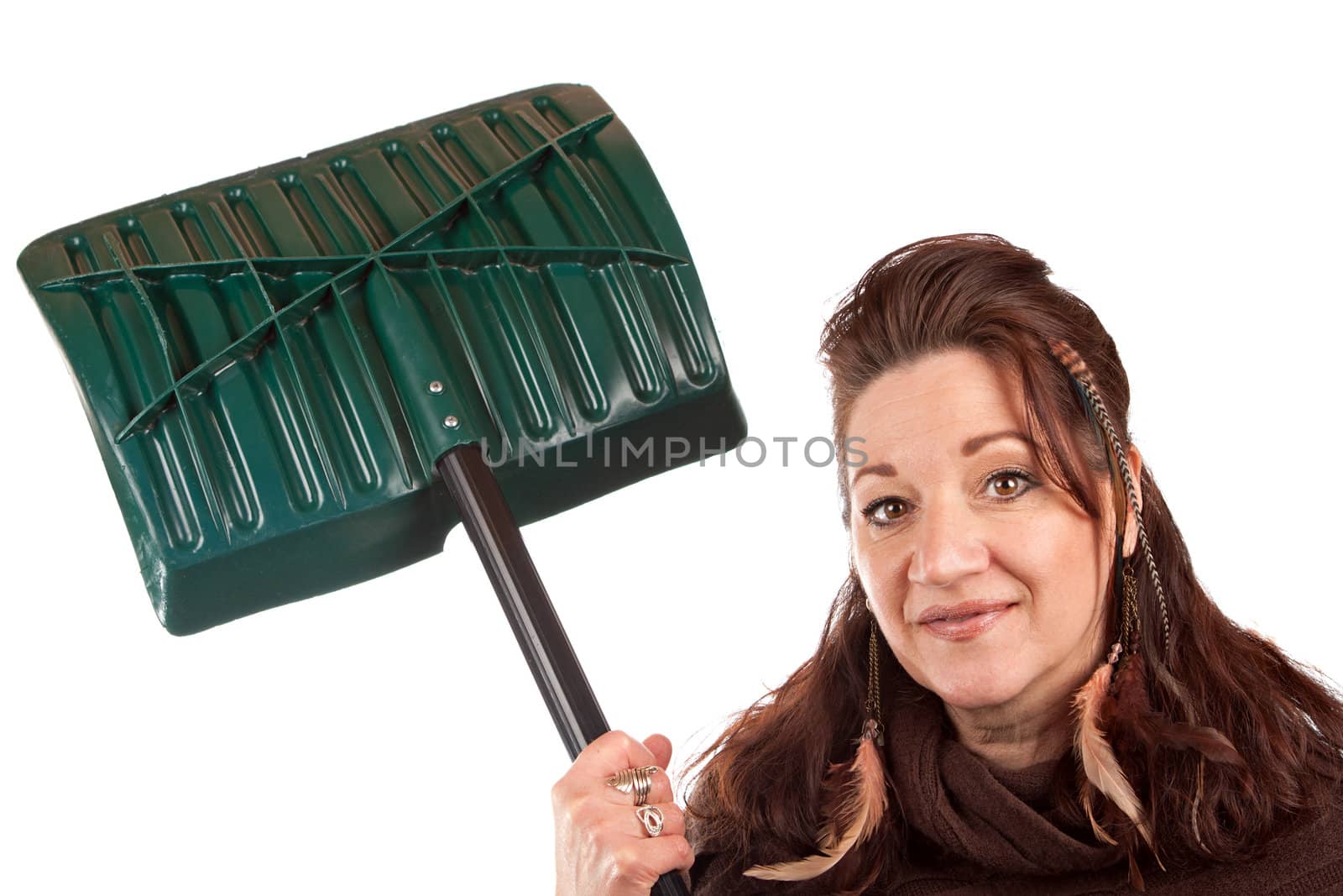 Brunette woman holding up her snow shovel isolated over a white backdrop.