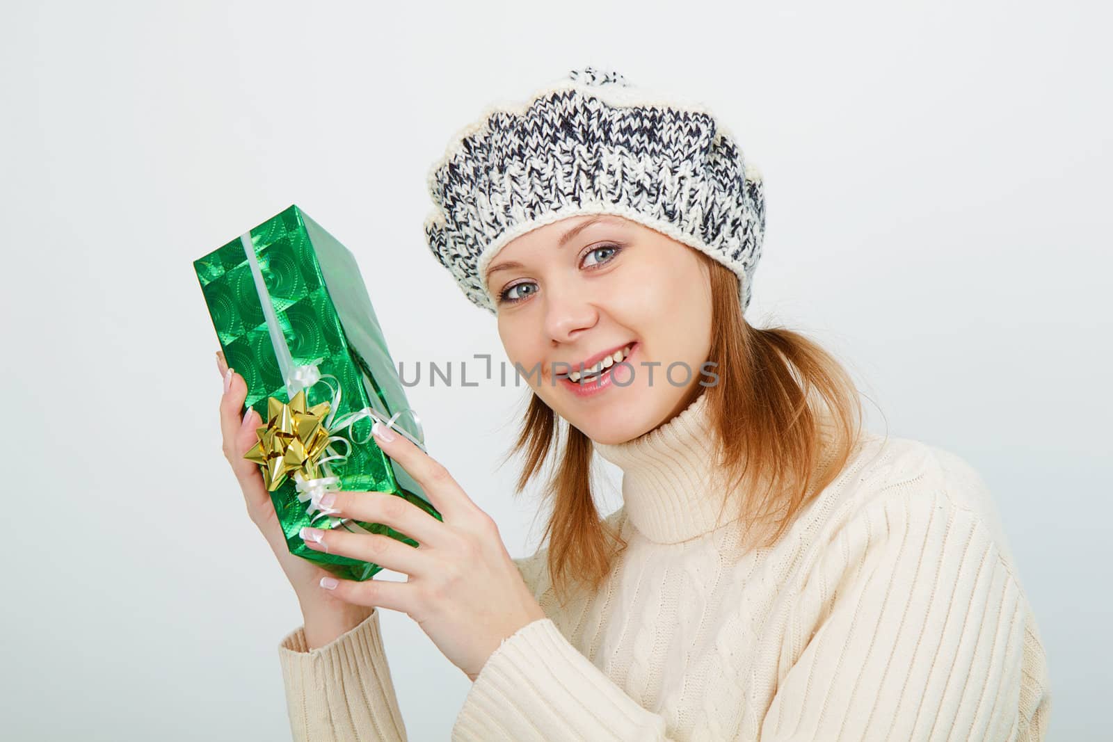 Attractive girl with a gift on a light background