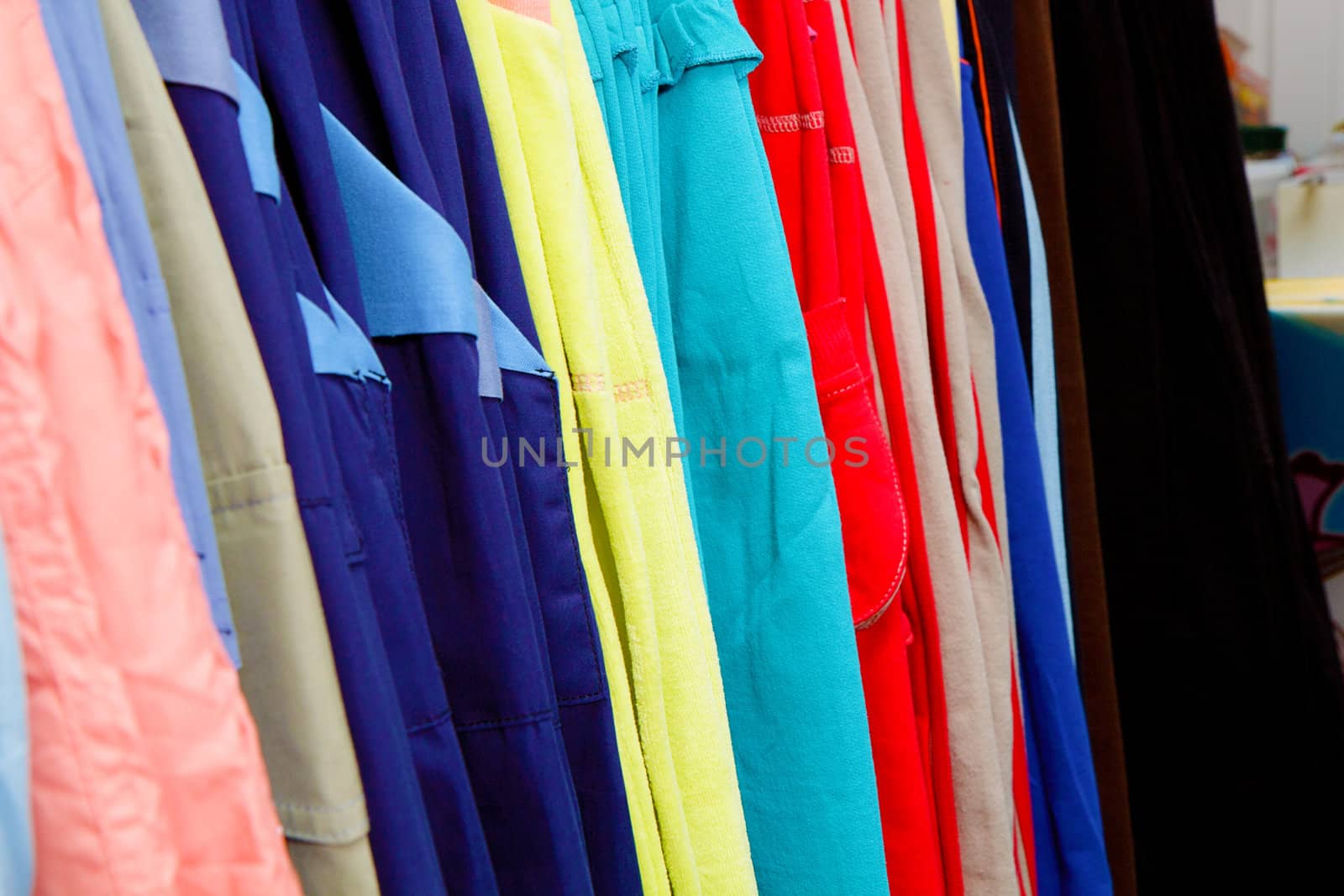 a lot of bright children's clothing on a hanger in the store