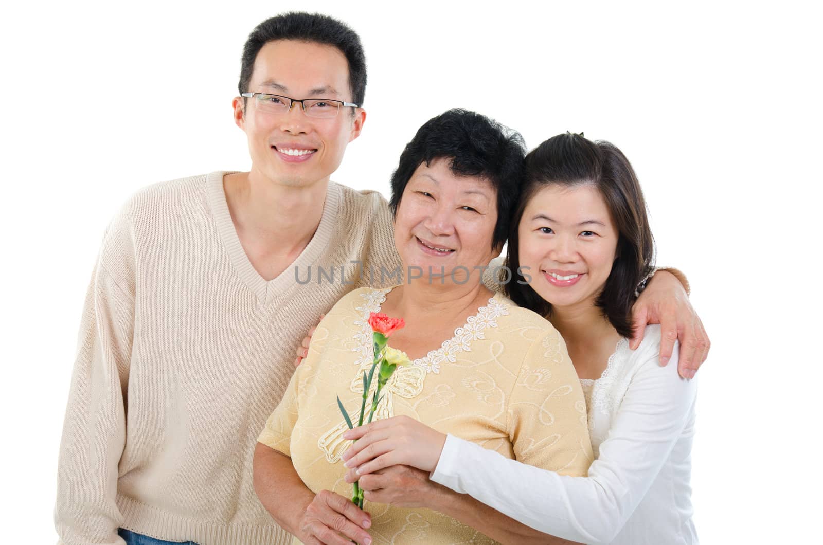 Asian family celebrates Mothers Day. Adult offspring giving carnation flowers to senior mother isolated on white.