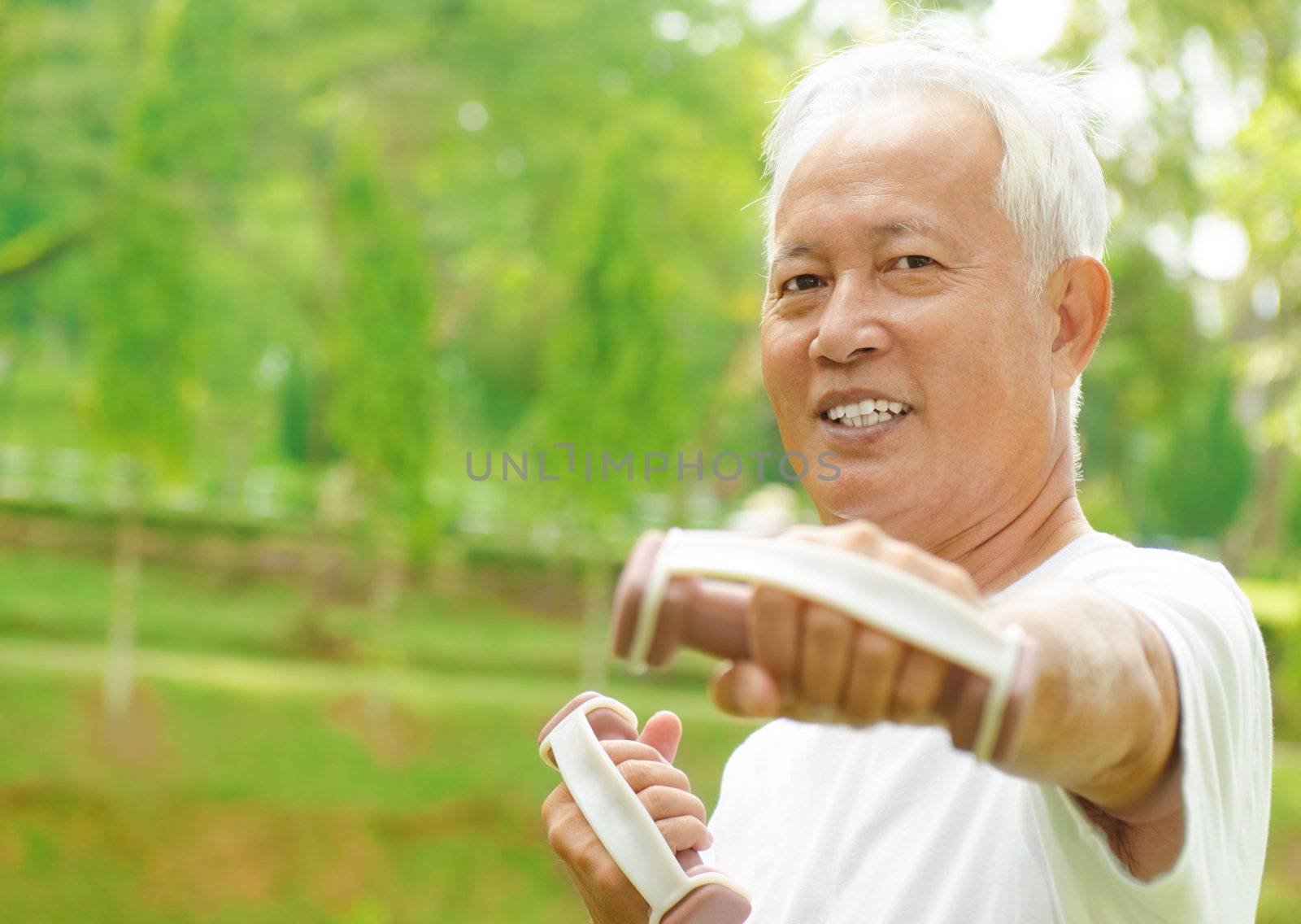 Asian senior man healthy lifestyle. Happy Asian grandparent playing sport at outdoor green park. 