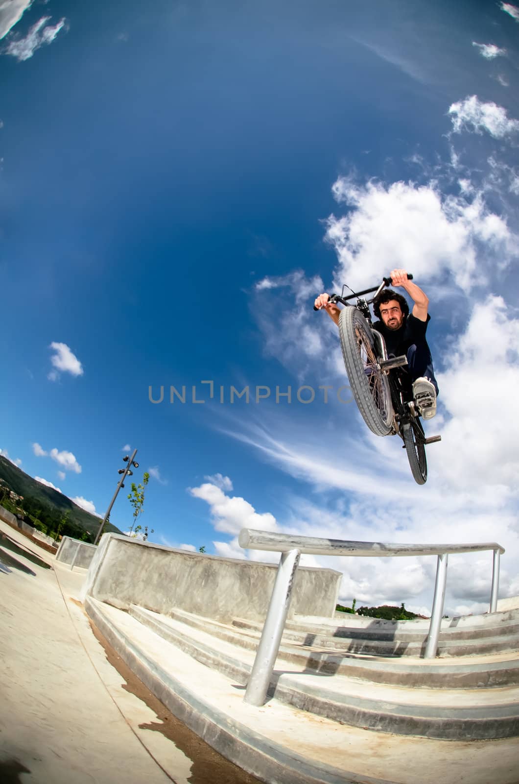 Bmx rider on a big air jump in a skate park.