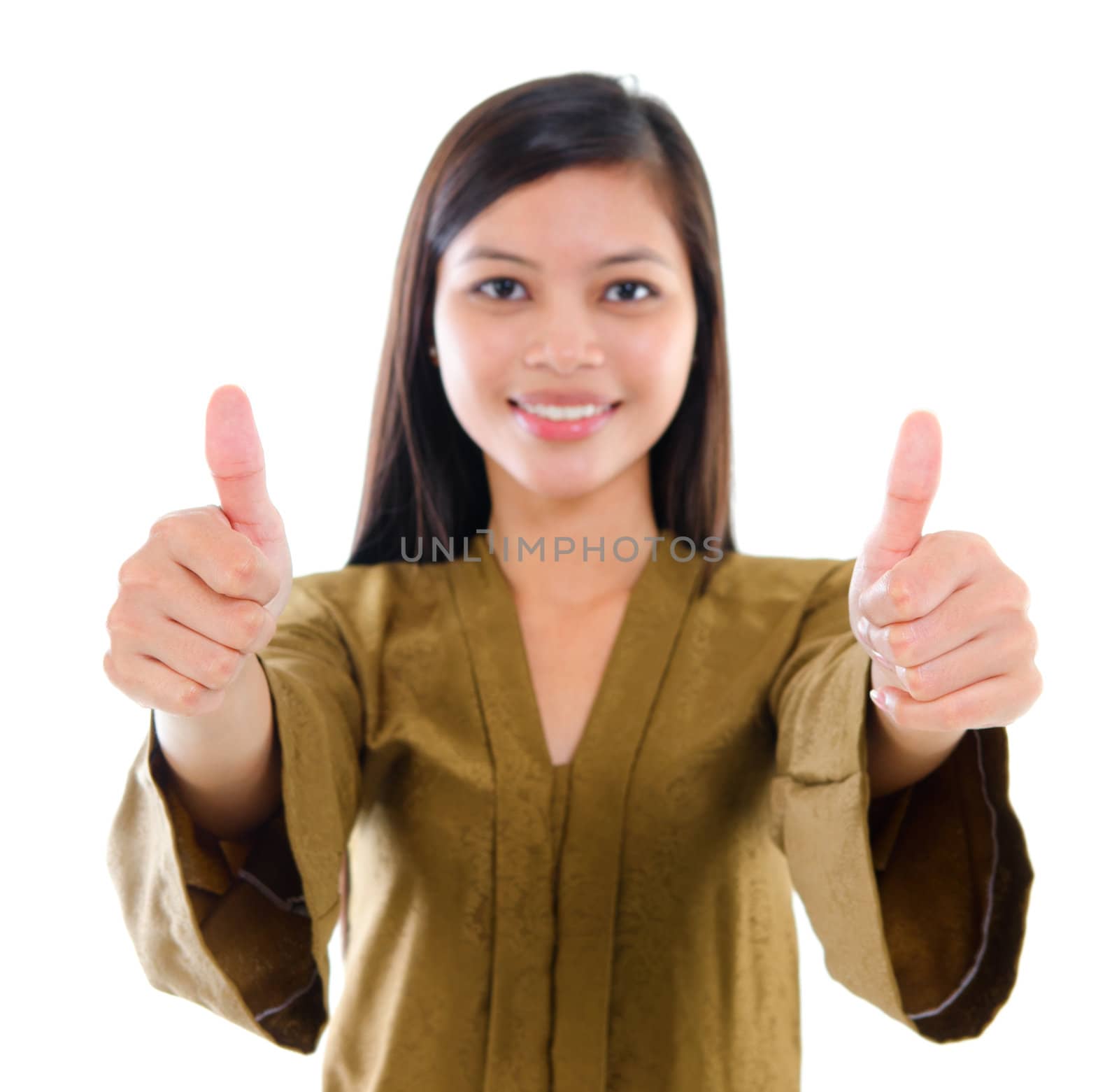 Southeast Asian Muslim female in traditional kebaya with long black hair giving thumbs up sign with great smile standing isolated on white background.