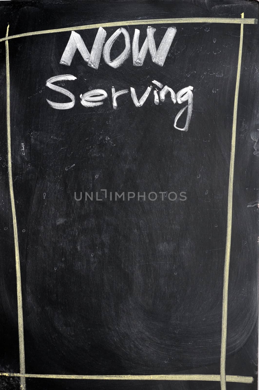 Menu of now serving written with chalk on a blackboard