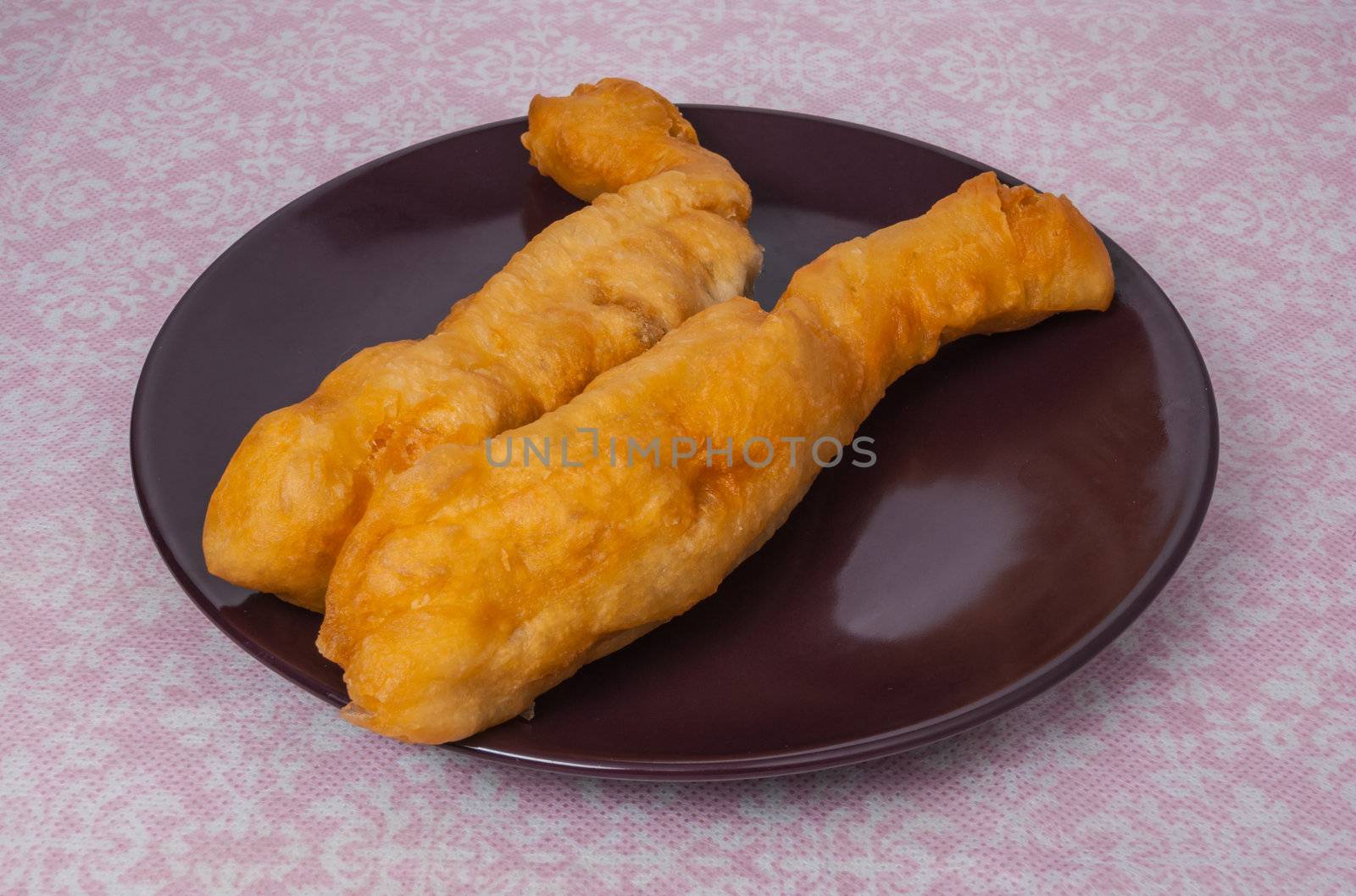 Youtiao (Chinese name) is very famous in Southeast Asia especially Chinese where the origin country of Youtiao. In Thailand, it is generally called Pathongko due to a confusion with a different kind of dessert. Youtiao called Chinese oil stick, Chinese donut, Chinese cruller, fried bread stick- is a long, golden-brown, deep fried strip of dough. Youtiao or Pathongko is lightly salted and made so they can be torn lengthwise in two. Youtiao are normally eaten as an accompaniment for rice congee or soy milk. In Thailand, Pathongko is also dipped into condensed milk or, in the South, eaten with kaya.