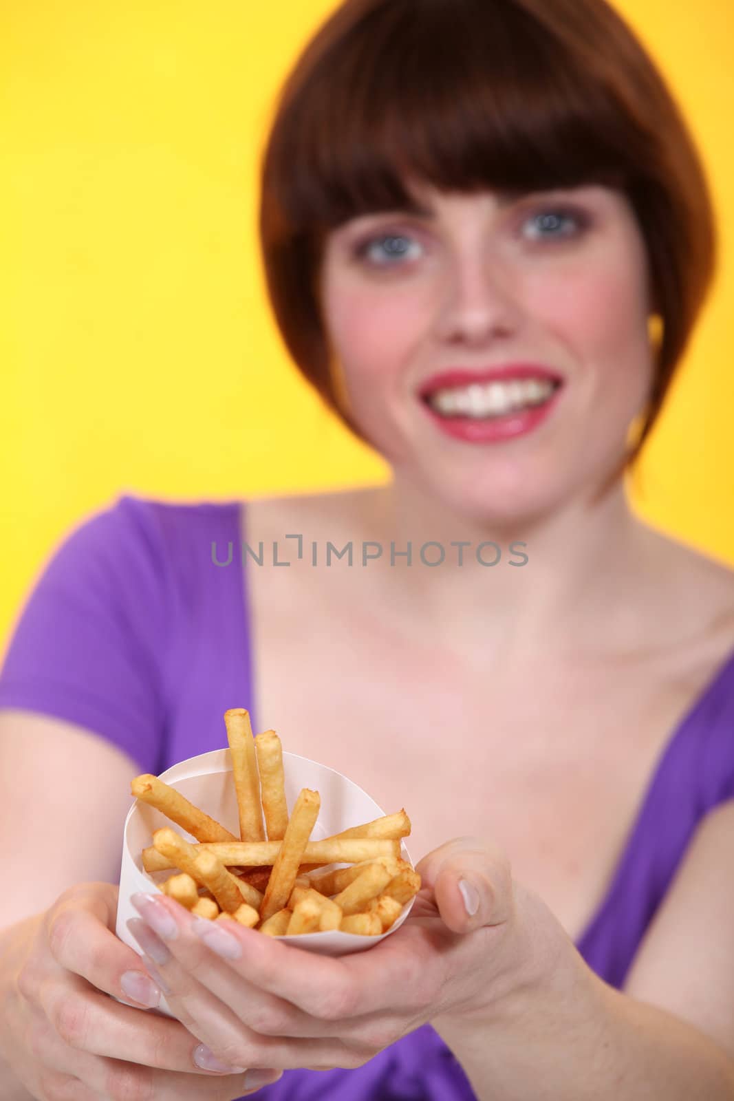 Young woman proposing French fries by phovoir