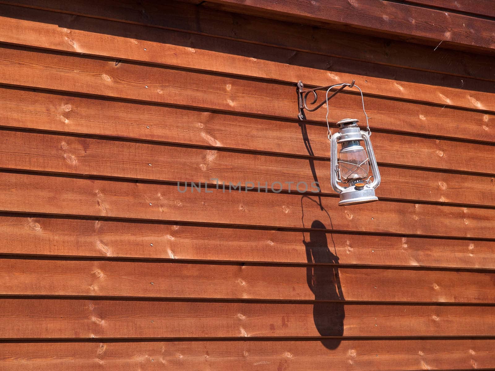 Classical oil lamp hanged on a wooden wall