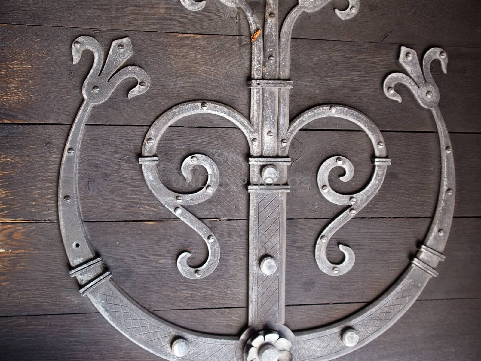 Closeup detailes of an old antique wooden door with handmade craft metal decoration