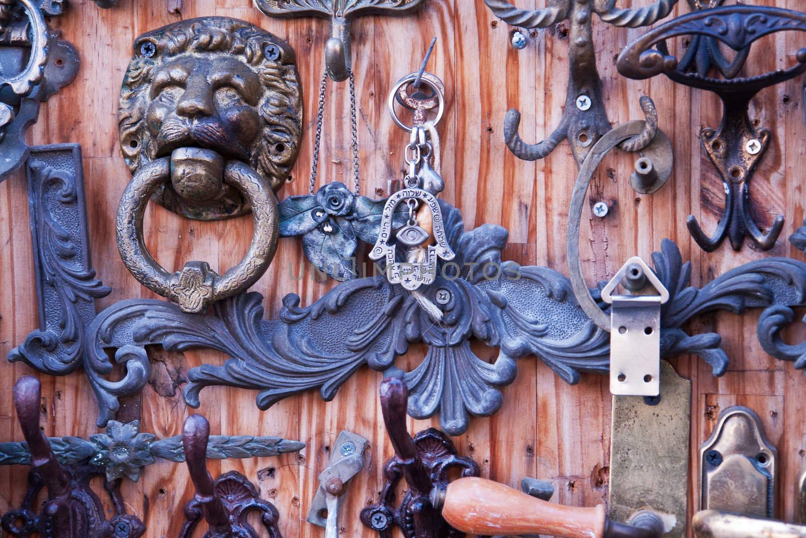 Collection of handmade metal door knockers on display in street flea market