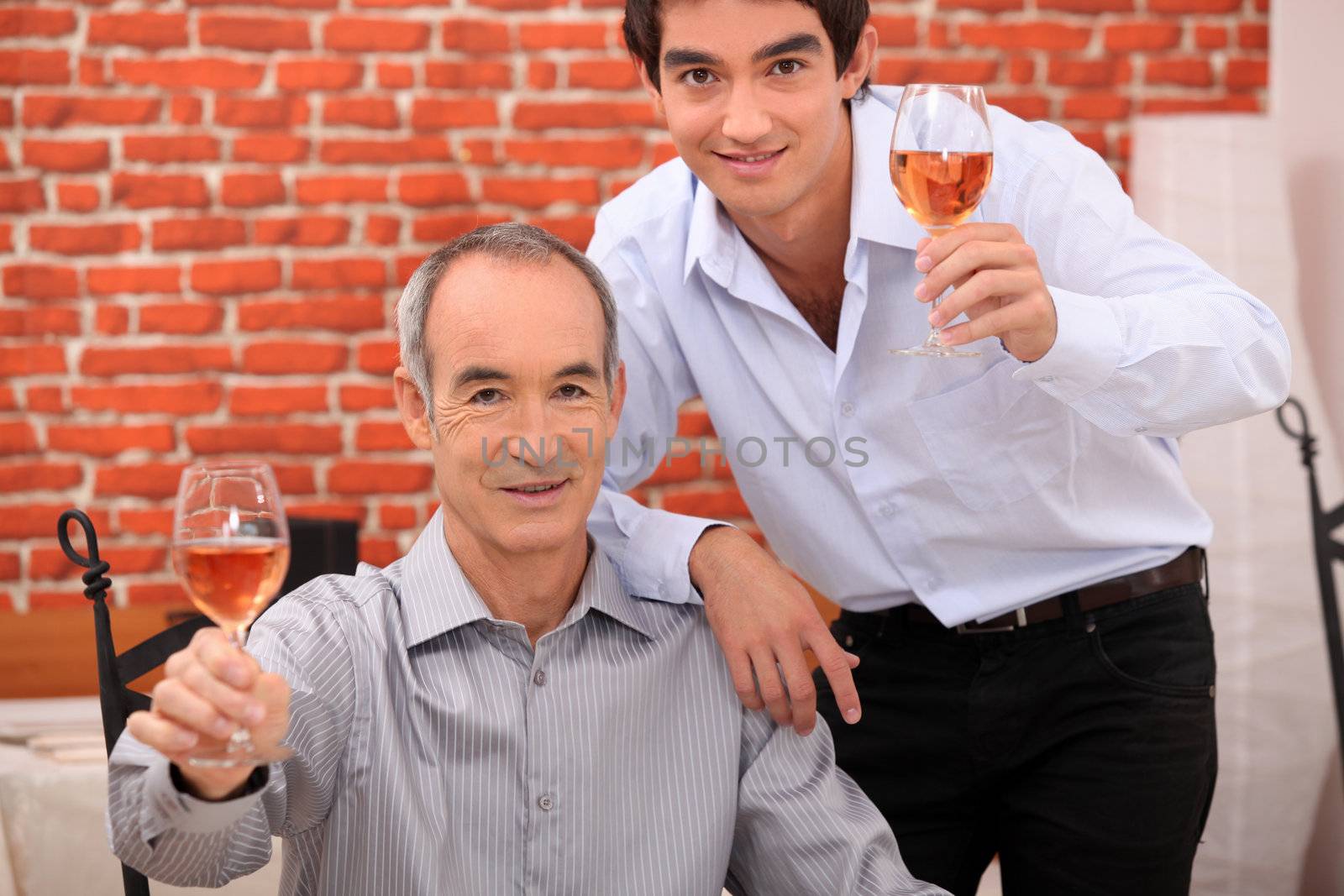 Men raising their glasses in a toast by phovoir