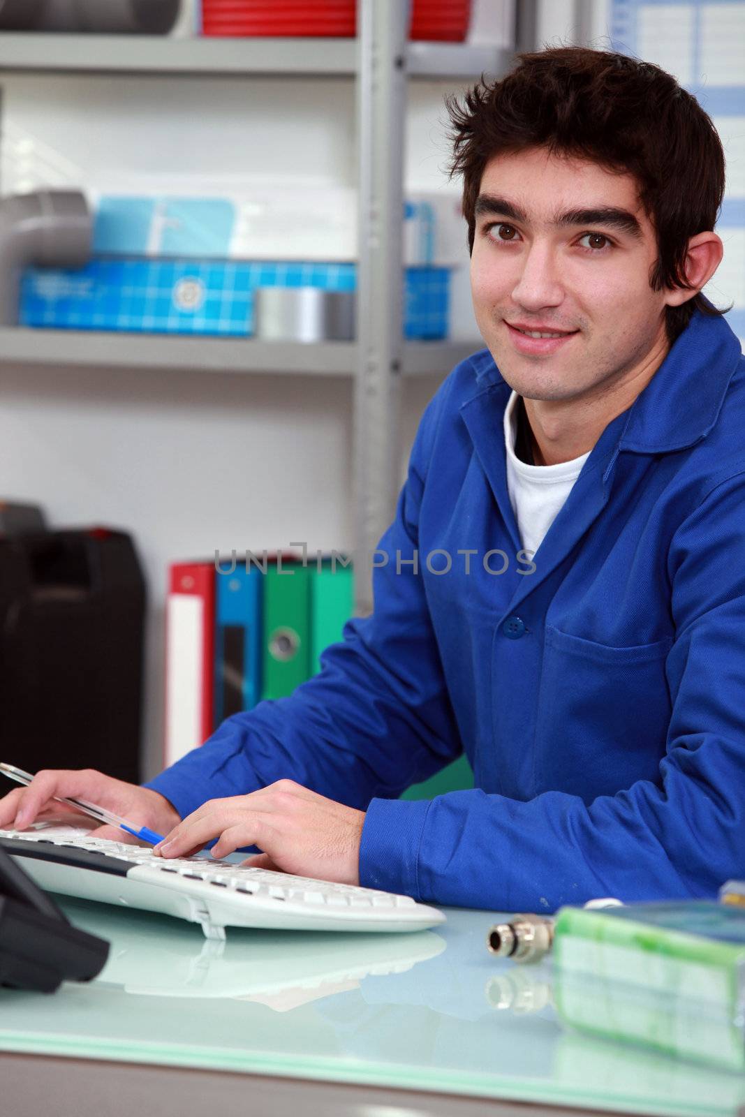 Young apprentice doing paperwork. by phovoir