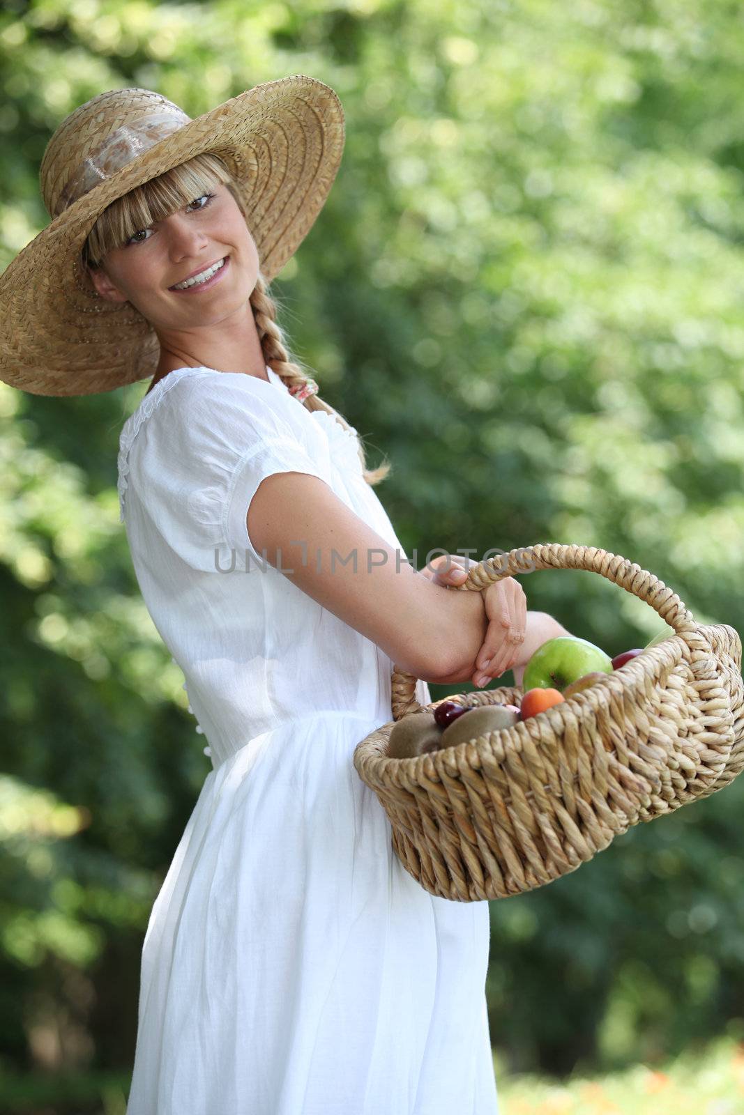 young woman with a basket of fresh fruits by phovoir