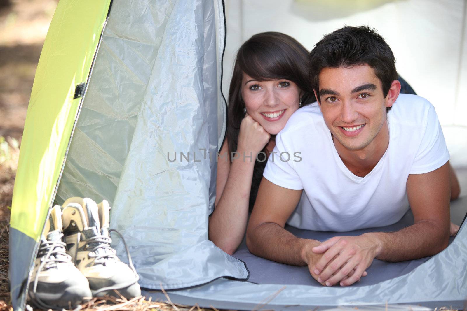 Teenage couple in a tent by phovoir