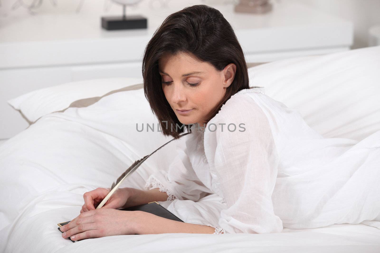 a woman writing diaries with a feather by phovoir