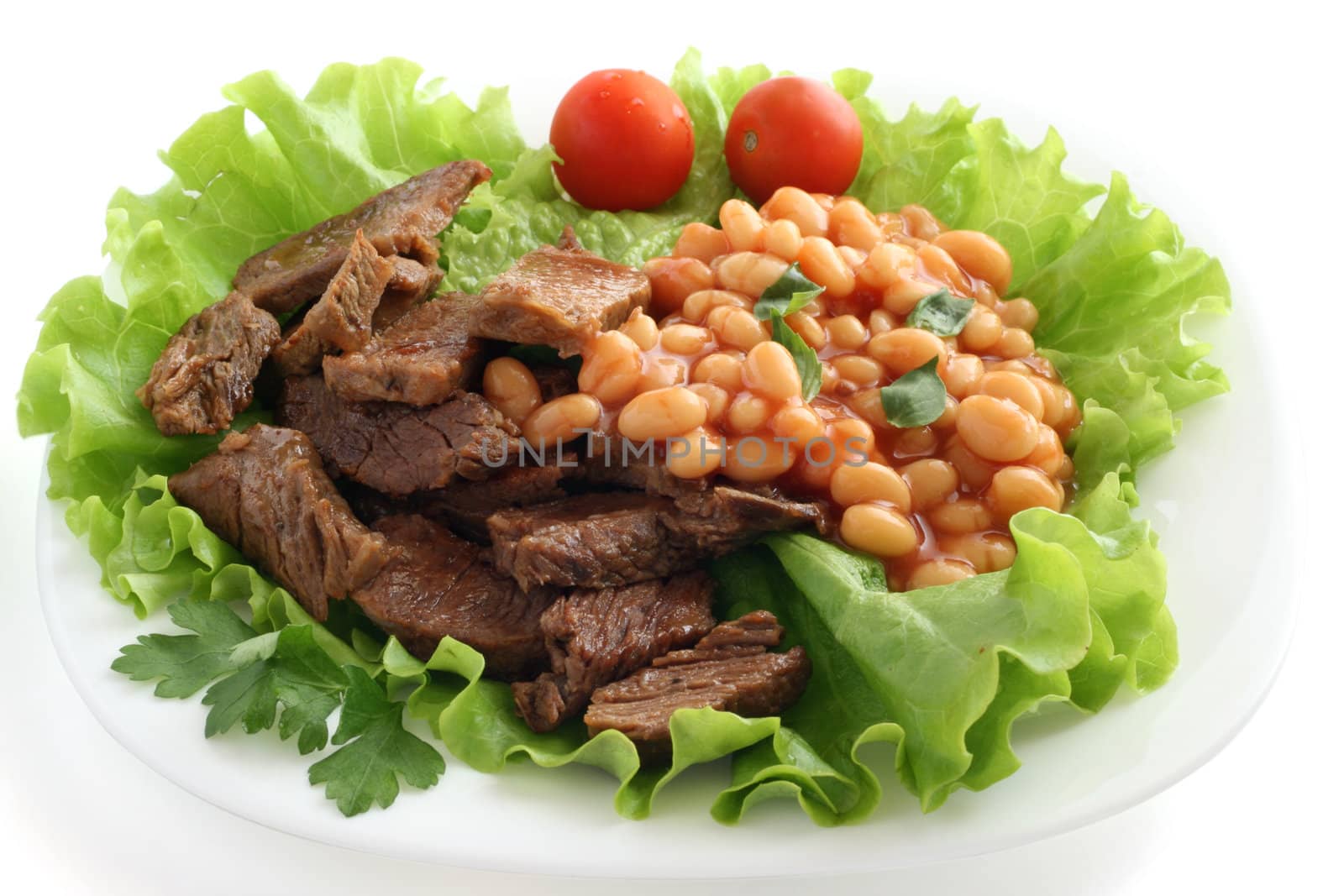 fried beef with beans on lettuce