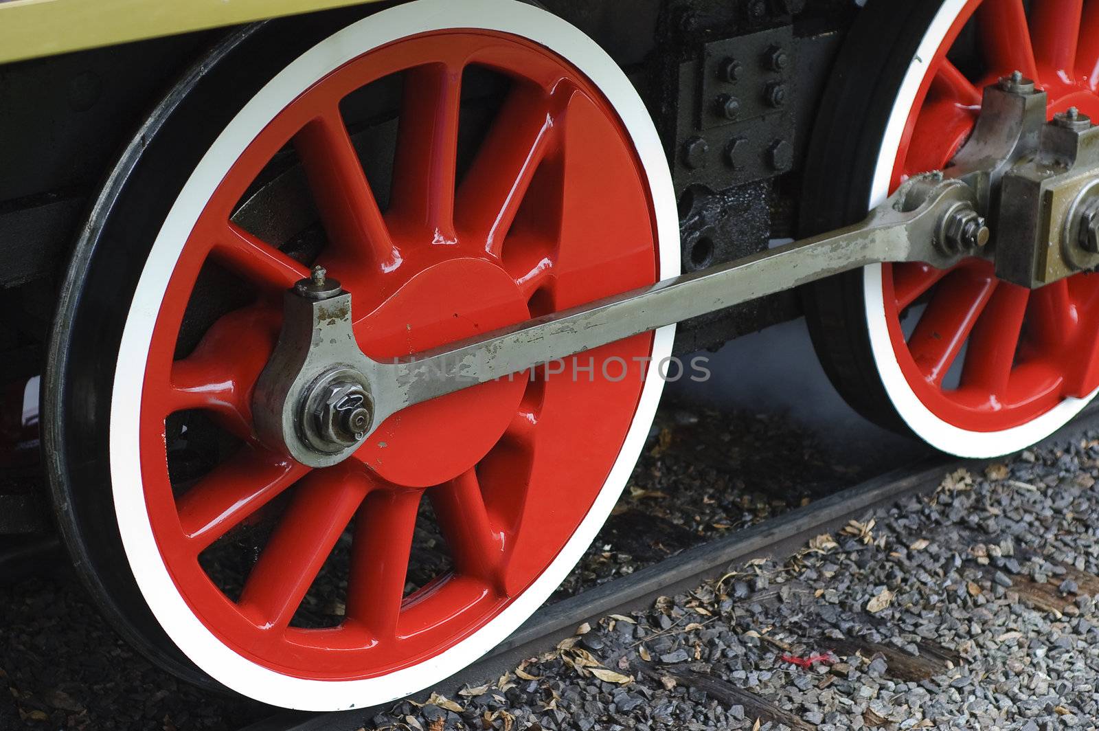 Horizontal image of two red steam train wheels